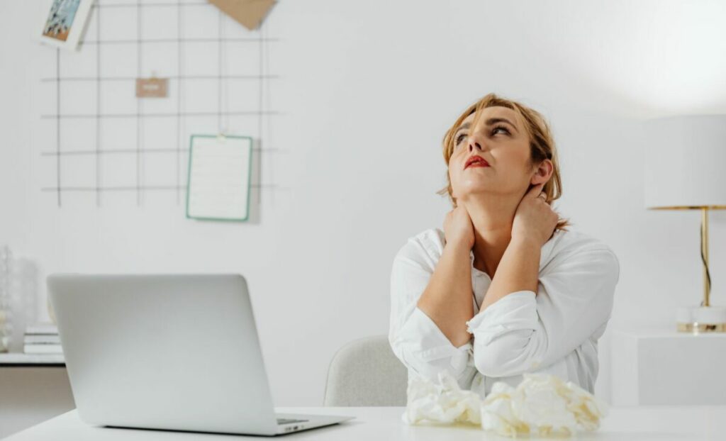 Salariée avec des douleurs au cou devant son ordinateur
