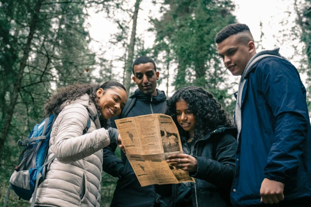 Groupe qui lit une carte en forêt : course d'orientation