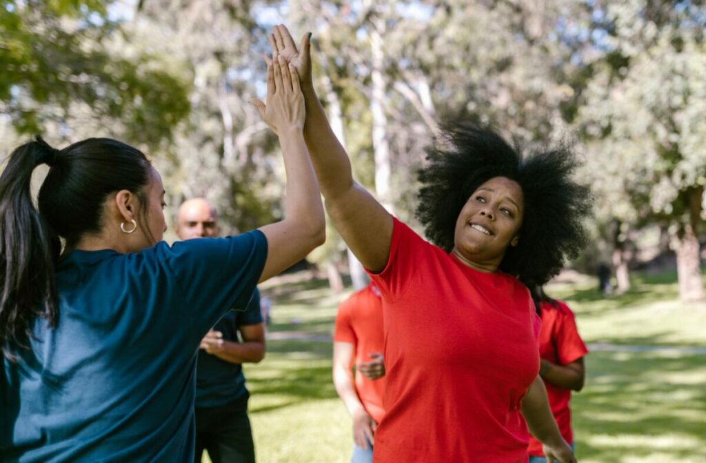 Équipe se tapant dans la main pendant un team building en extérieur